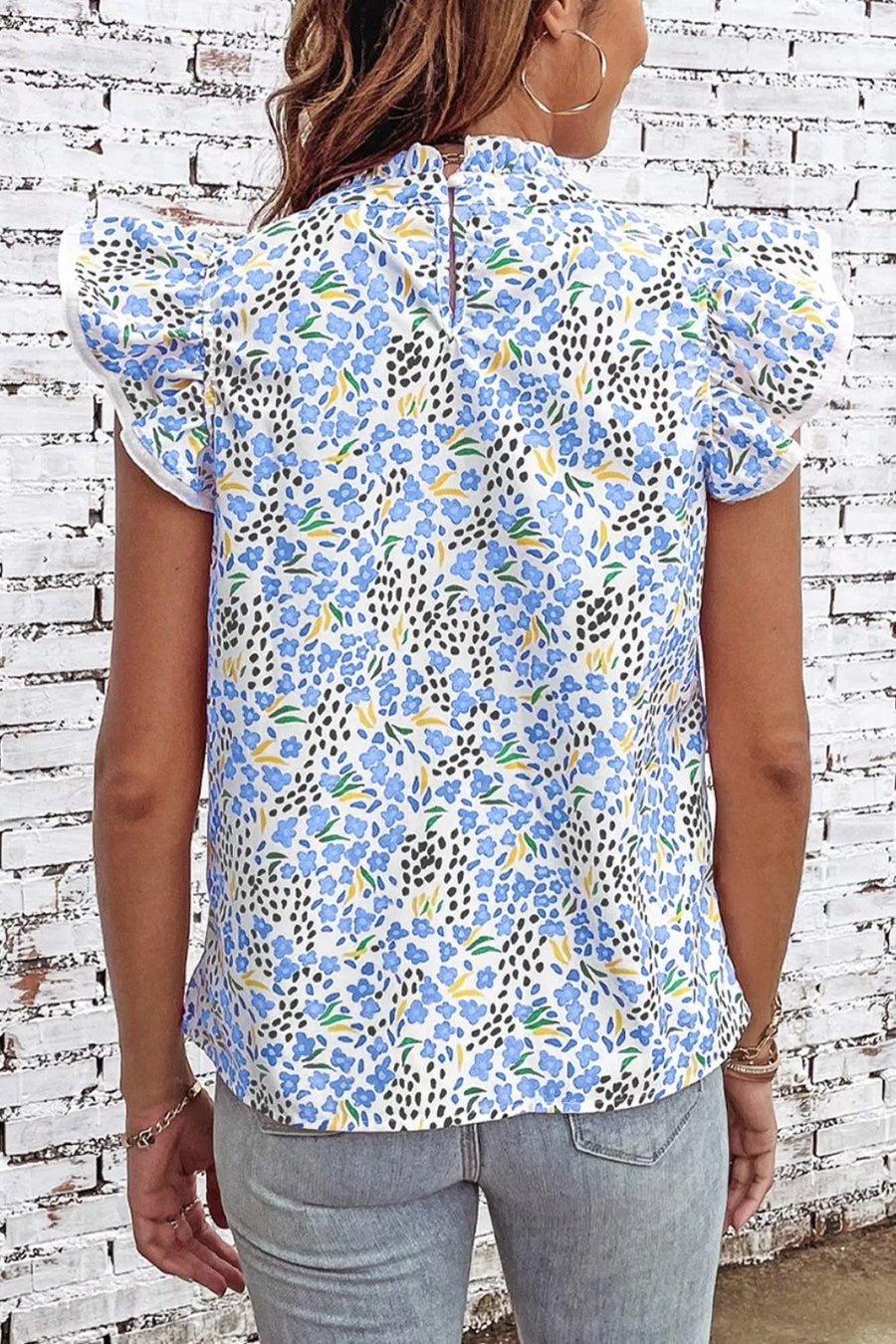 Floral abstract high neck blouse with cap sleeves and ruffled details.