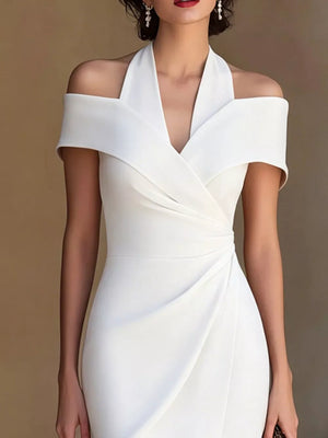 White asymmetrical midi dress with halter neckline and off-shoulder sleeves.