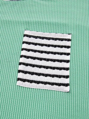 Turquoise long-sleeve top with twisted ribbing and a black and white striped pocket.