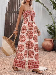 Charming floral tie-front wide-leg romper in cream with red print, strapless, and wide legs.