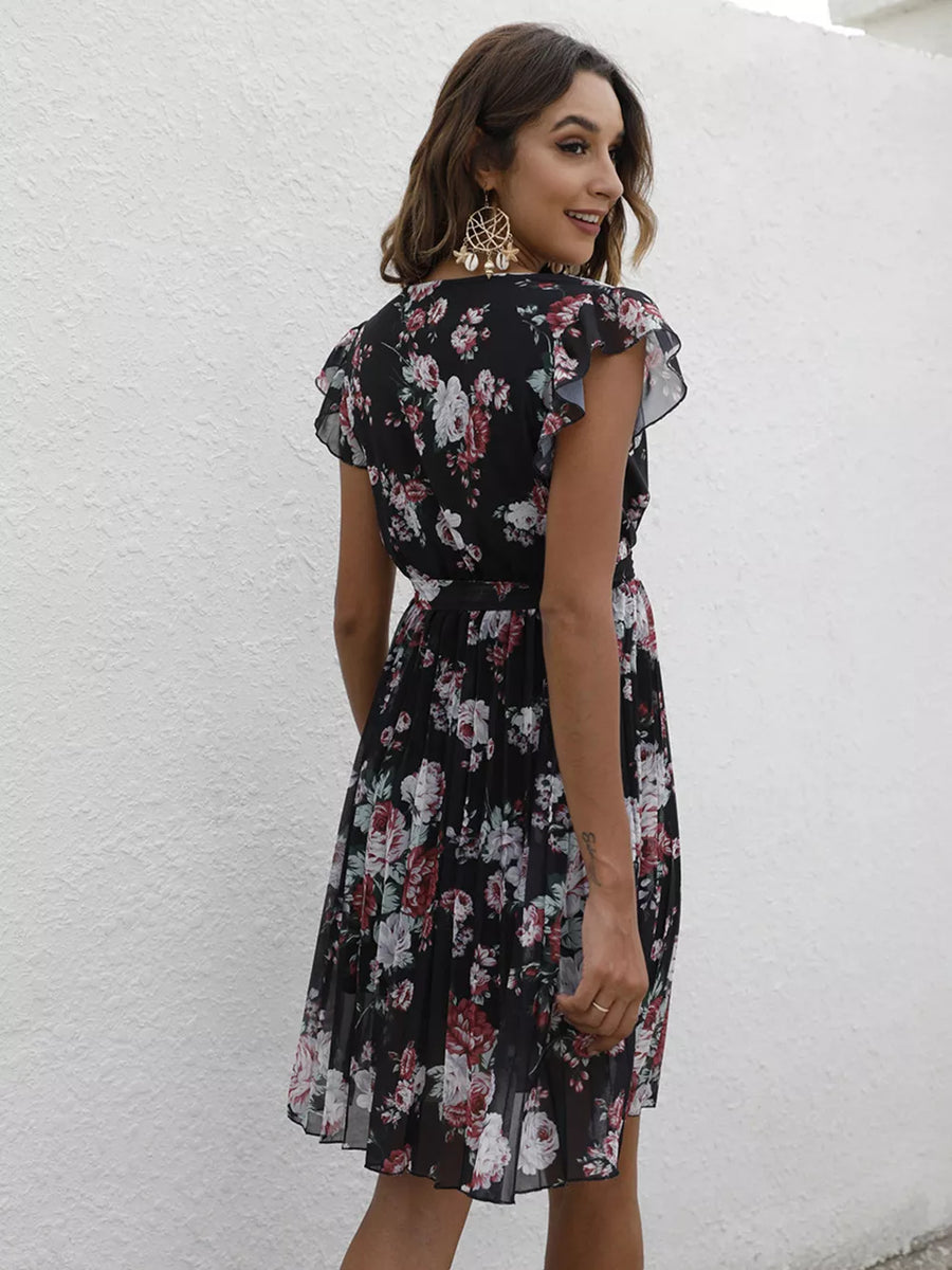 Black floral pleated dress with ruffle sleeves and a belted waist.