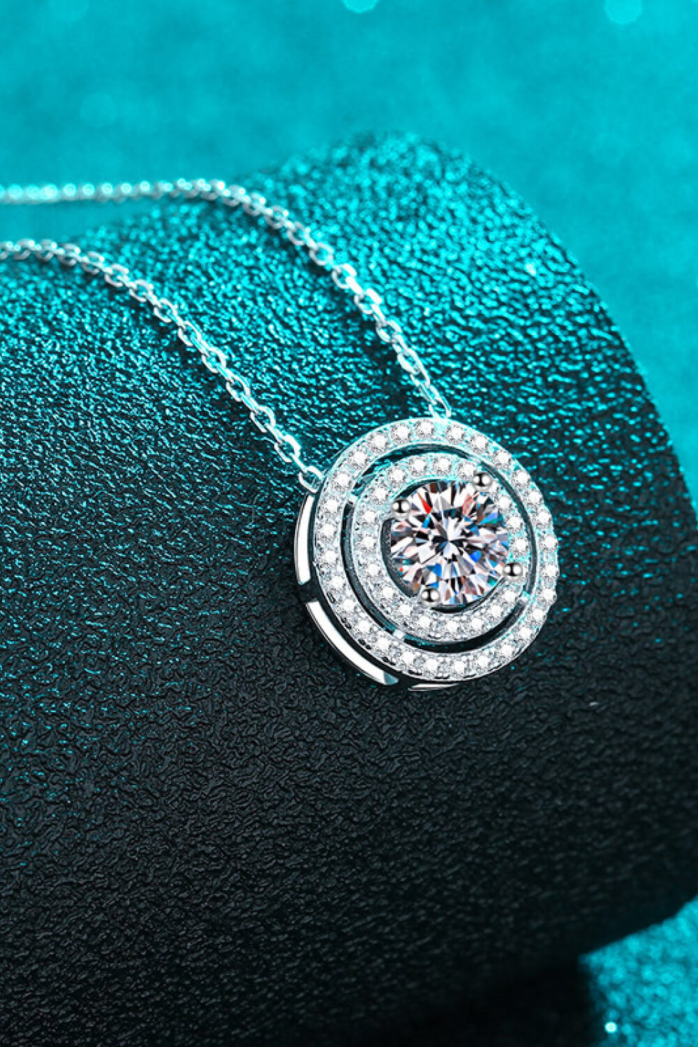 Silver halo diamond pendant necklace with a central sparkling stone and layered diamond accents.