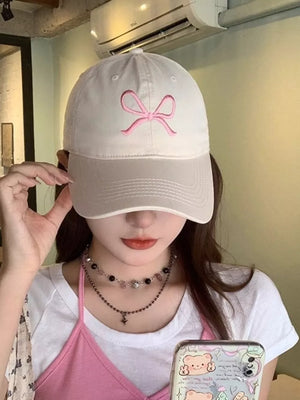 White baseball cap with pink bow embroidery, adjustable strap
