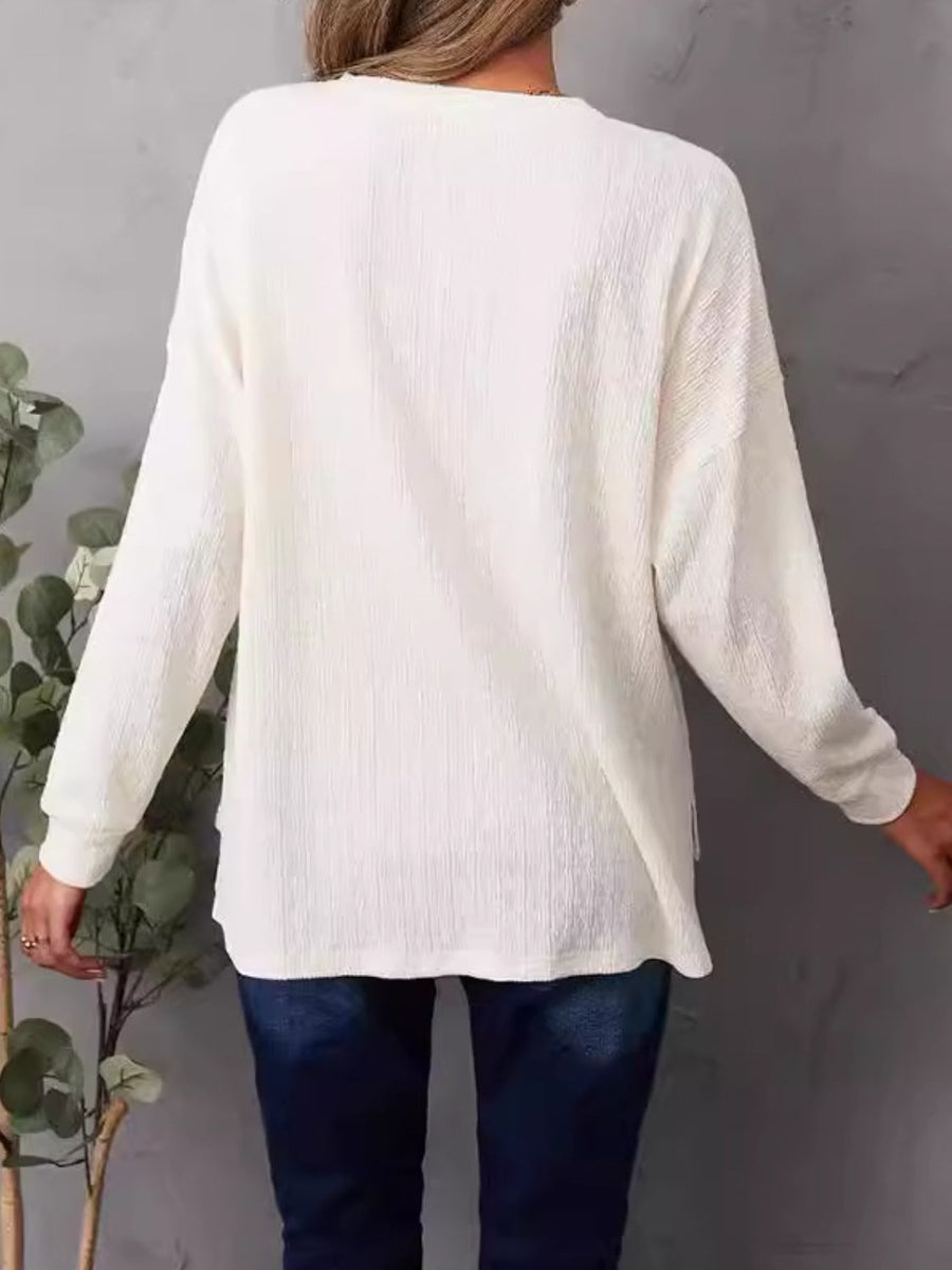Ivory waffle knit henley shirt with long sleeves and side slits.