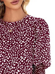 Burgundy animal print blouse with puff sleeves and smocked cuffs.