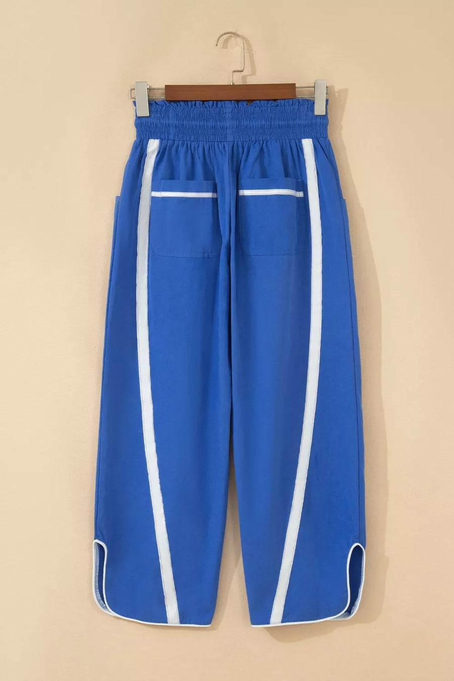 Blue smocked waist cropped casual pants with white side stripes and pocket trim.