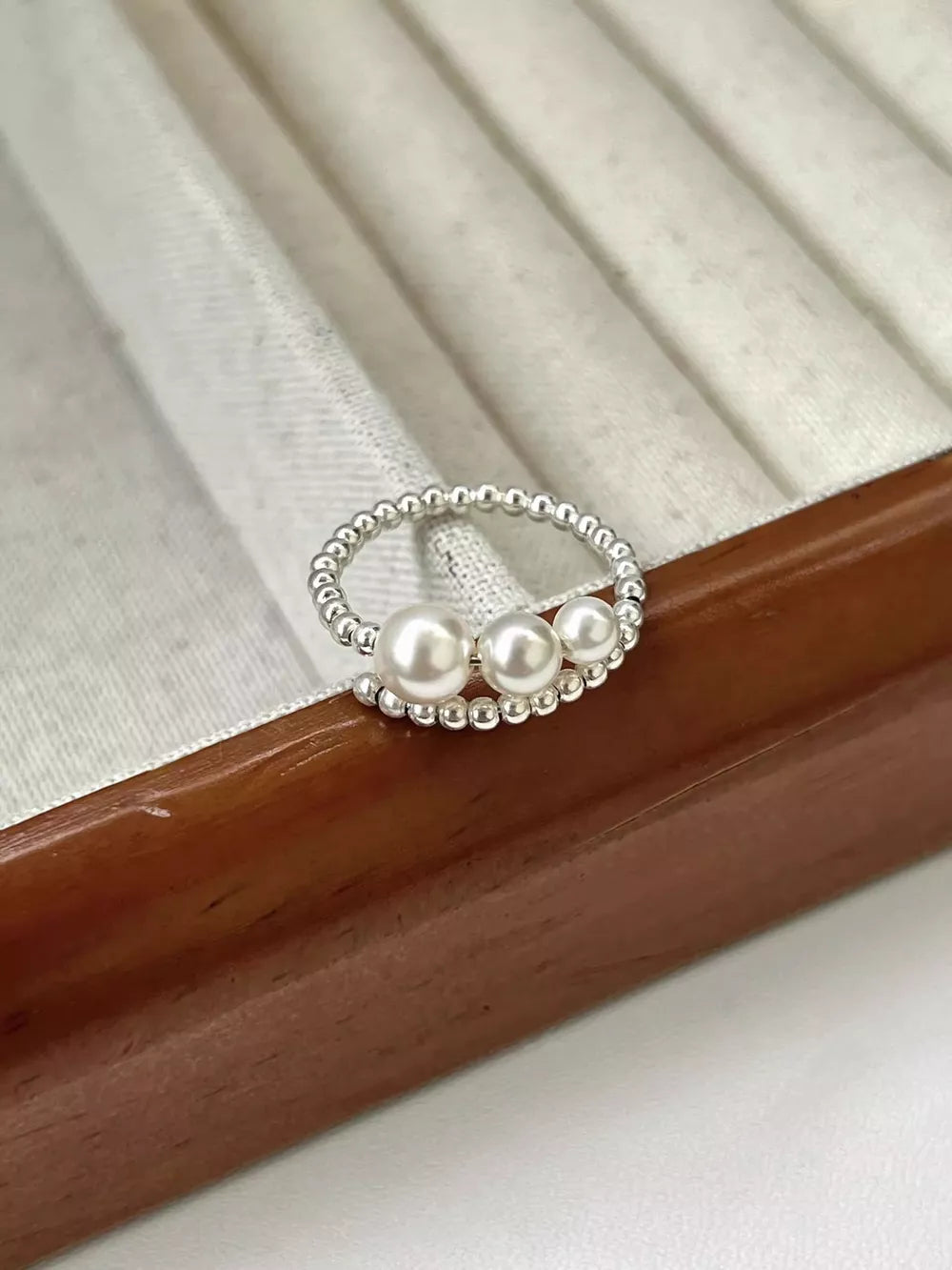 ring in silver featuring triple pearl and bypass fit