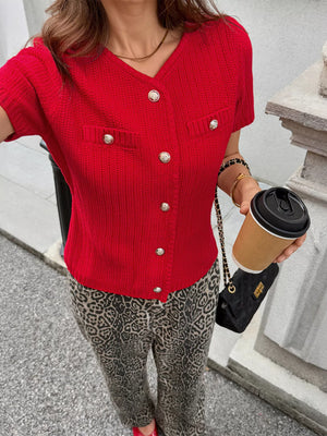 Red buttoned short-sleeve cardigan with V-neck and decorative pockets.