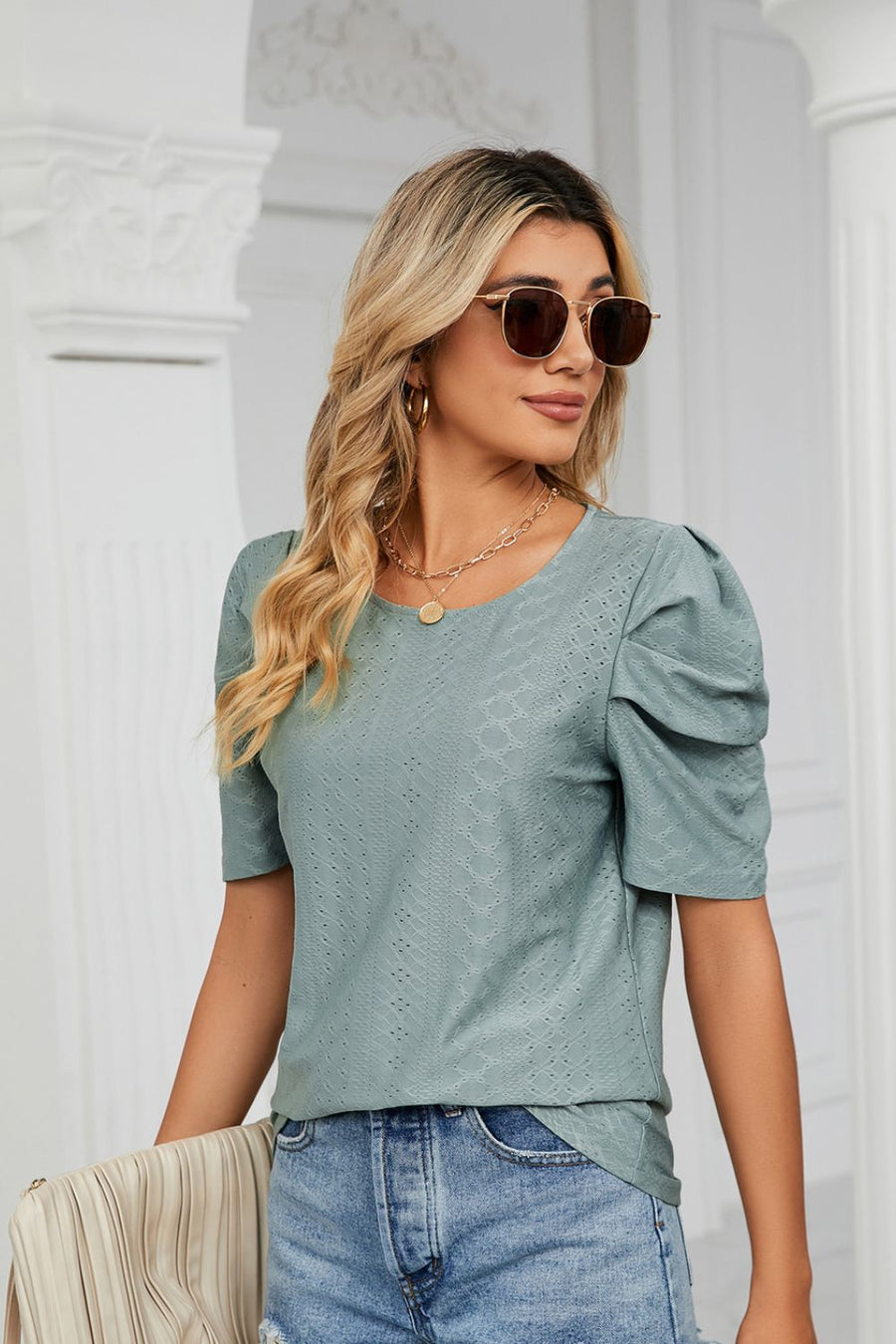 Teal perforated sleeve volume blouse with round neckline and puff sleeves.