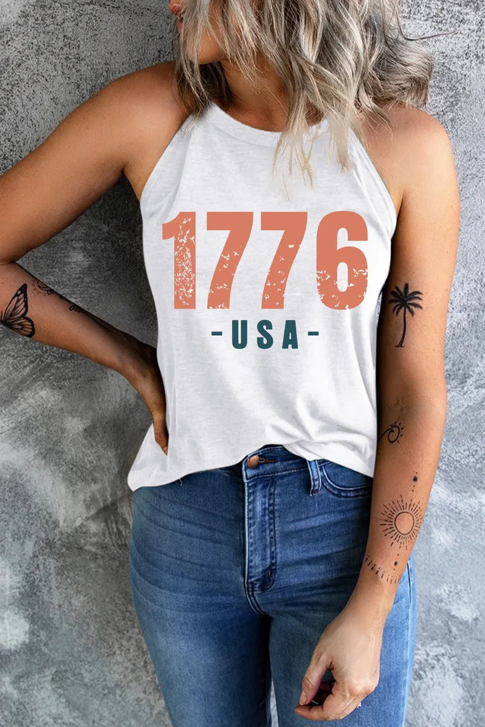 White halter tank top with distressed 1776 USA graphic, paired with blue jeans.