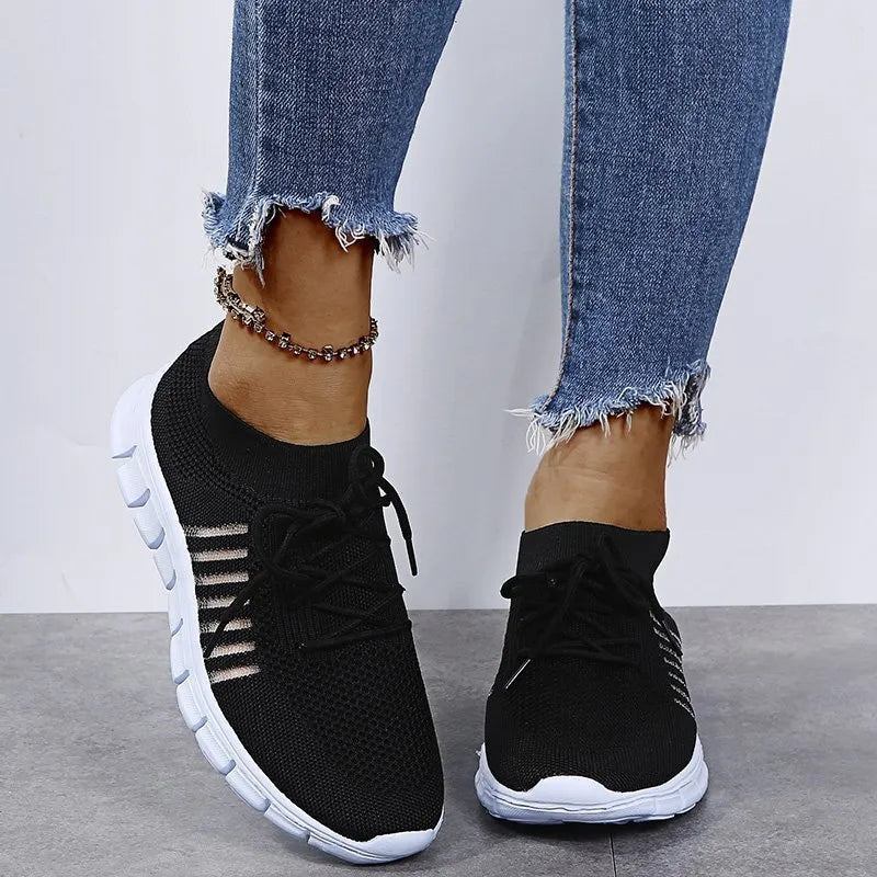 Black knit runner sneakers with ribbed lace-up detail and white soles.