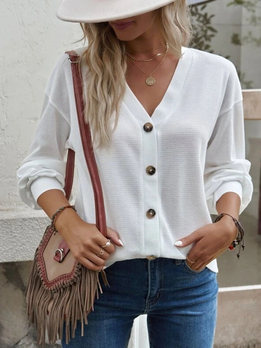 White waffle knit button-down cardigan with V-neck and brown buttons.