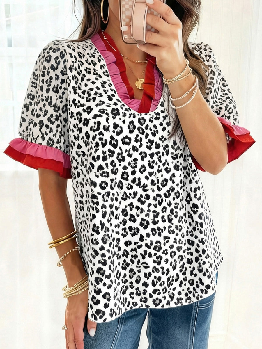 Leopard print blouse with ruffled neckline and sleeves in pink and red.