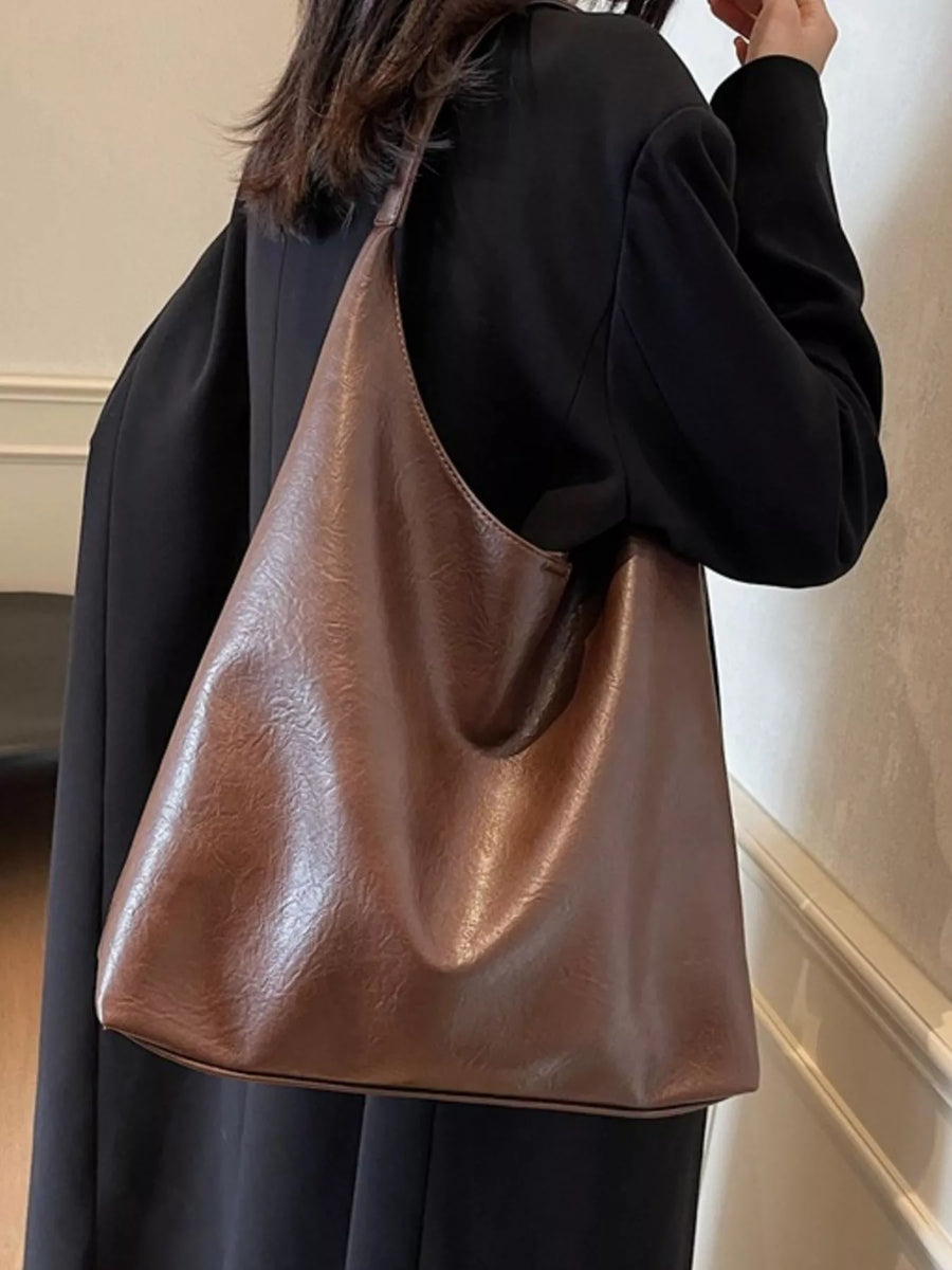 Sculptural PU leather tote bag in brown with a slouchy silhouette and single strap.