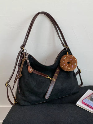 Black hobo bag with adjustable strap and donut charm accessory