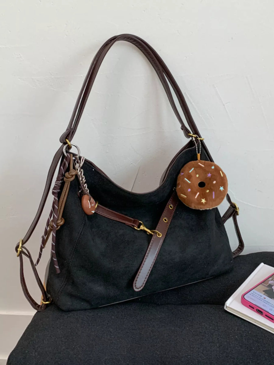 Black hobo bag with adjustable strap and donut charm accessory