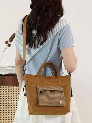 Brown nylon crossbody bag with plaid pocket detail and top handles.