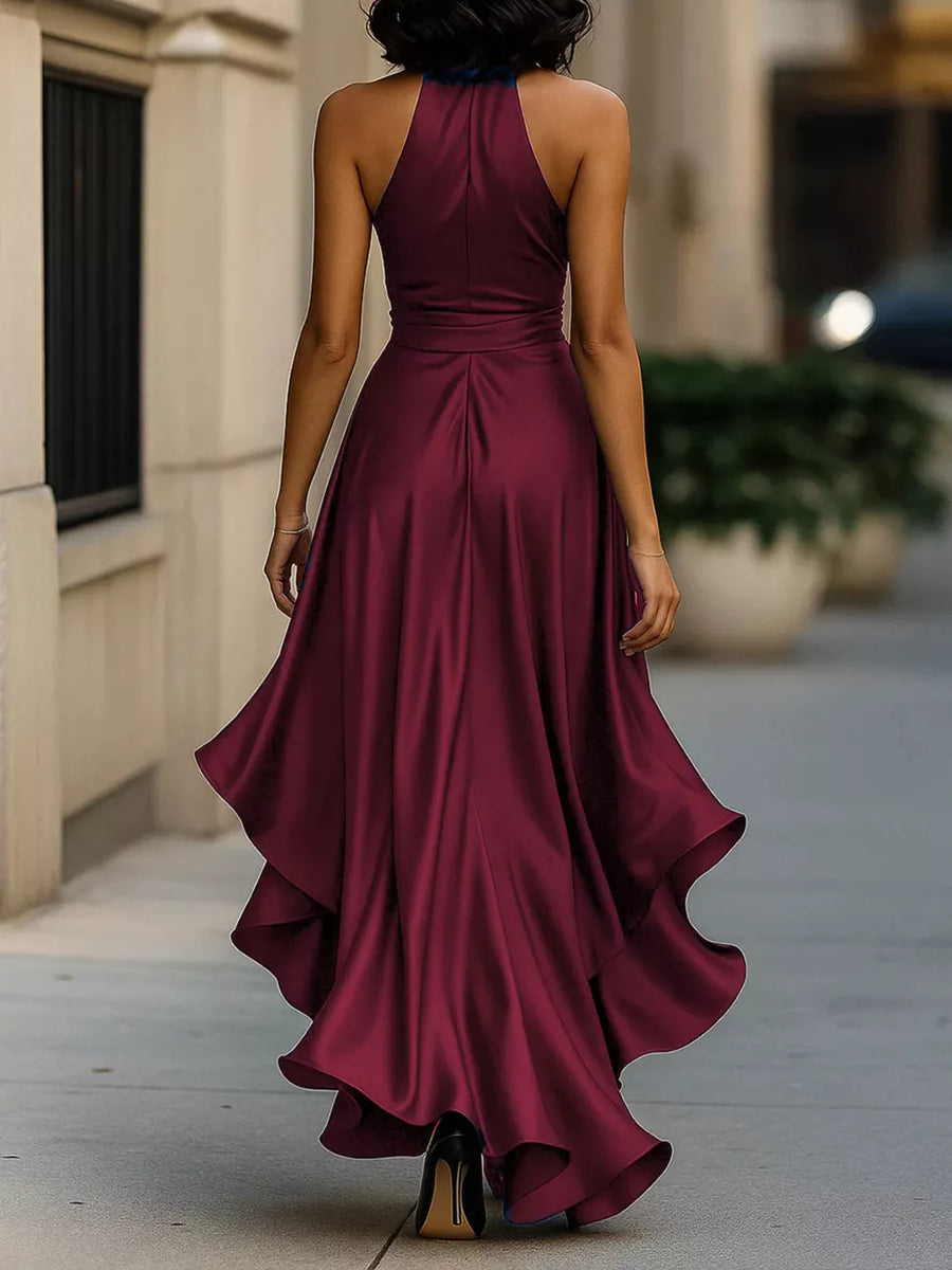 Burgundy halter maxi dress with ruffled asymmetrical hem and belted waist.