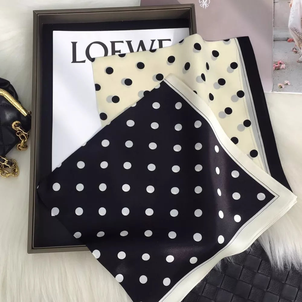 Sophisticated polka dot silk scarf in black and cream white with a bordered edge.