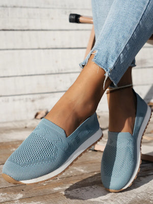 Light blue breathable knit slip-on sneakers with white soles.