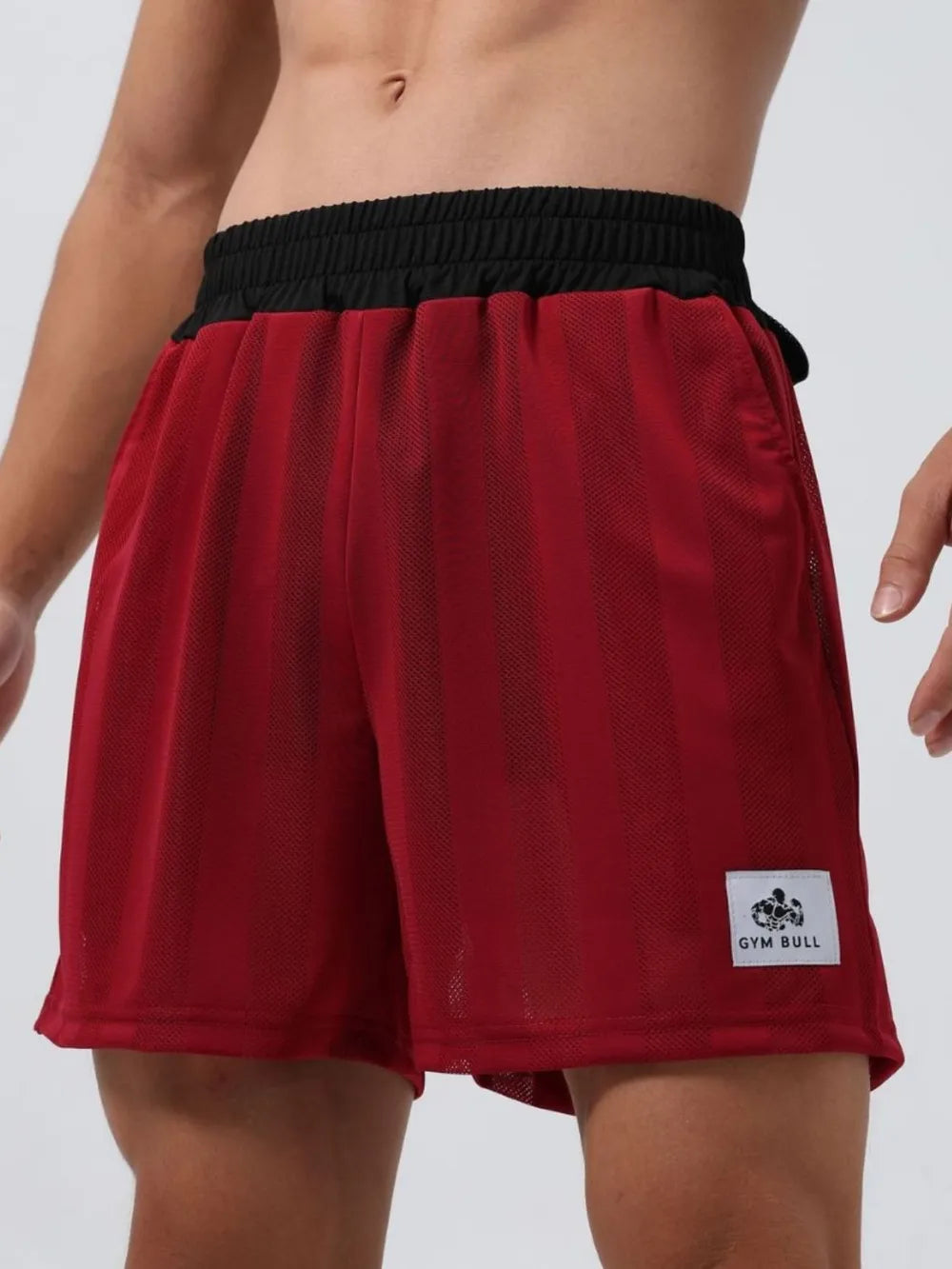 Deep red performance mesh training shorts with vertical stripes and black waistband.