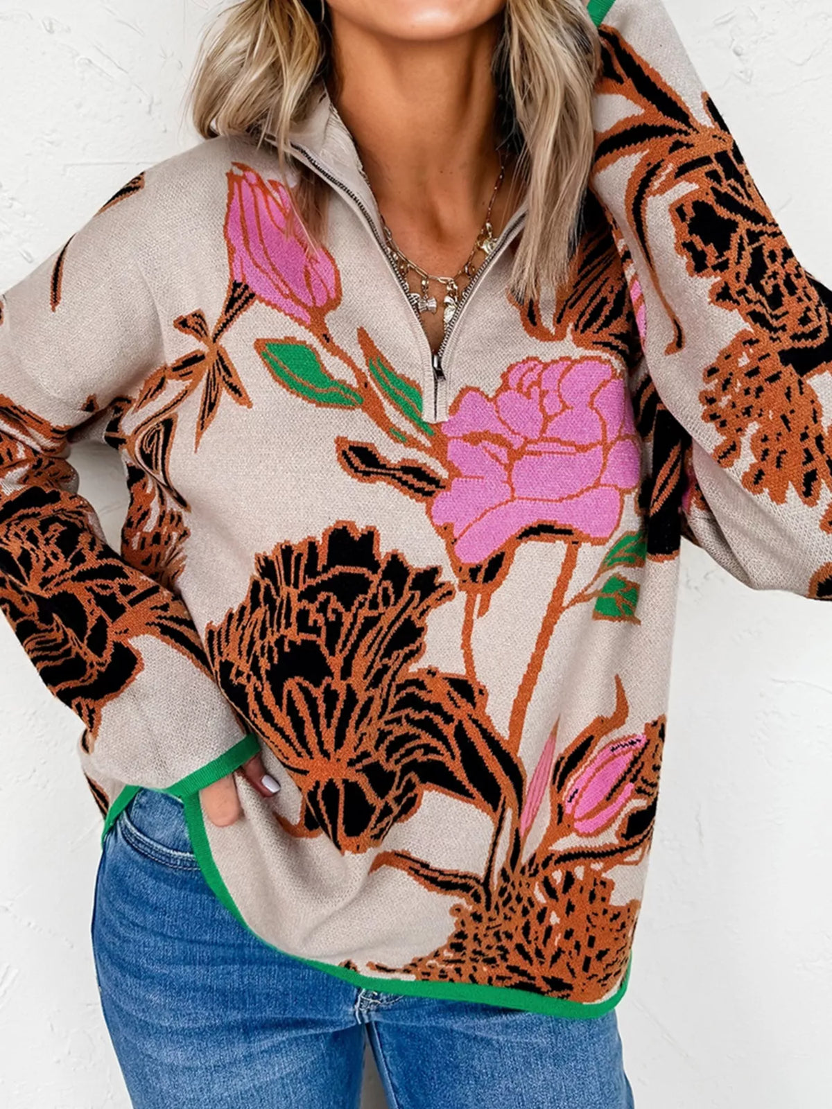 Knit quarter zip sweater in Floral pattern with stand neck and green trim.
