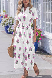 White cotton midi dress with pink floral print, V-neck, short sleeves, and smocked high waist.
