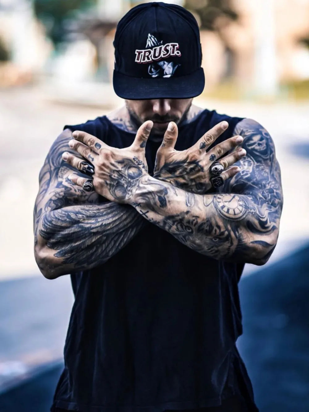 Black sleeveless tank top with a crew neck, worn by a tattooed man.