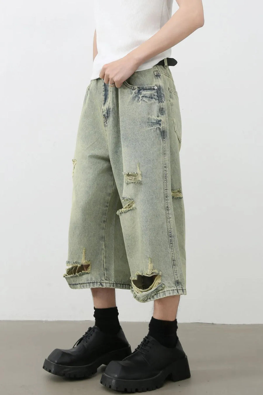 Distressed culotte denim shorts in medium wash with ripped details and a wide leg.