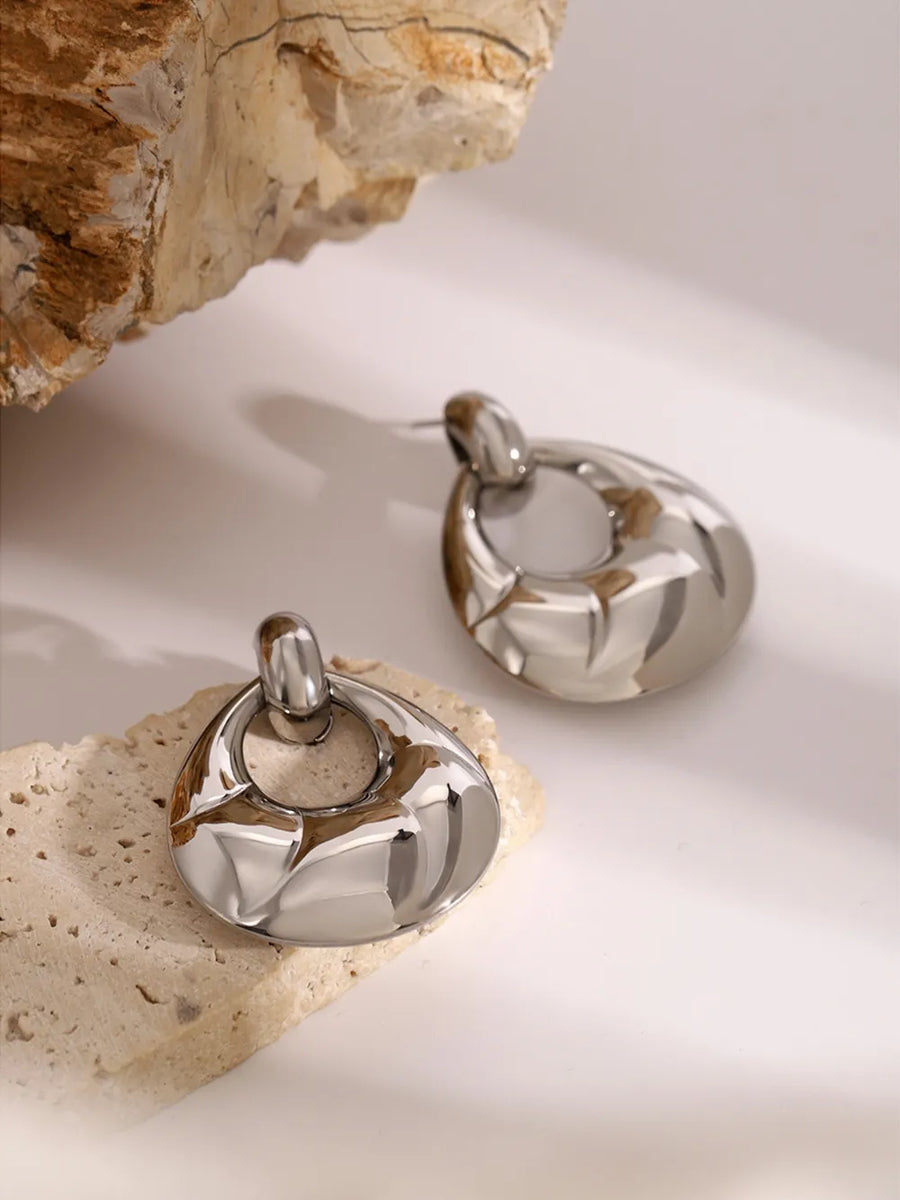 Sculpted silver statement earrings with a unique, abstract design.