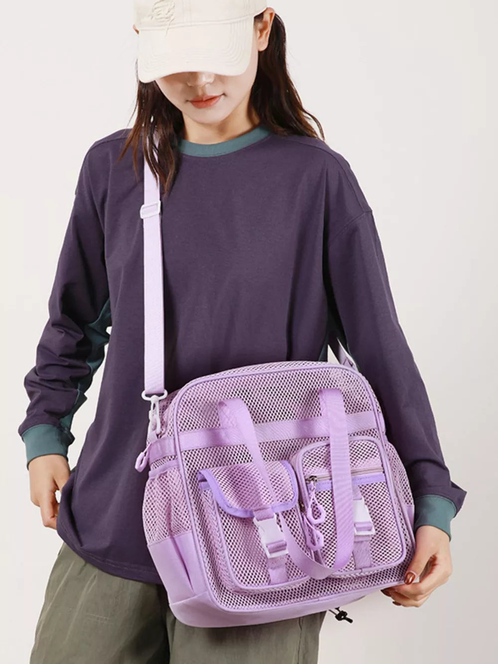 Lavender mesh crossbody bag with unique buckle accents and multiple pockets.