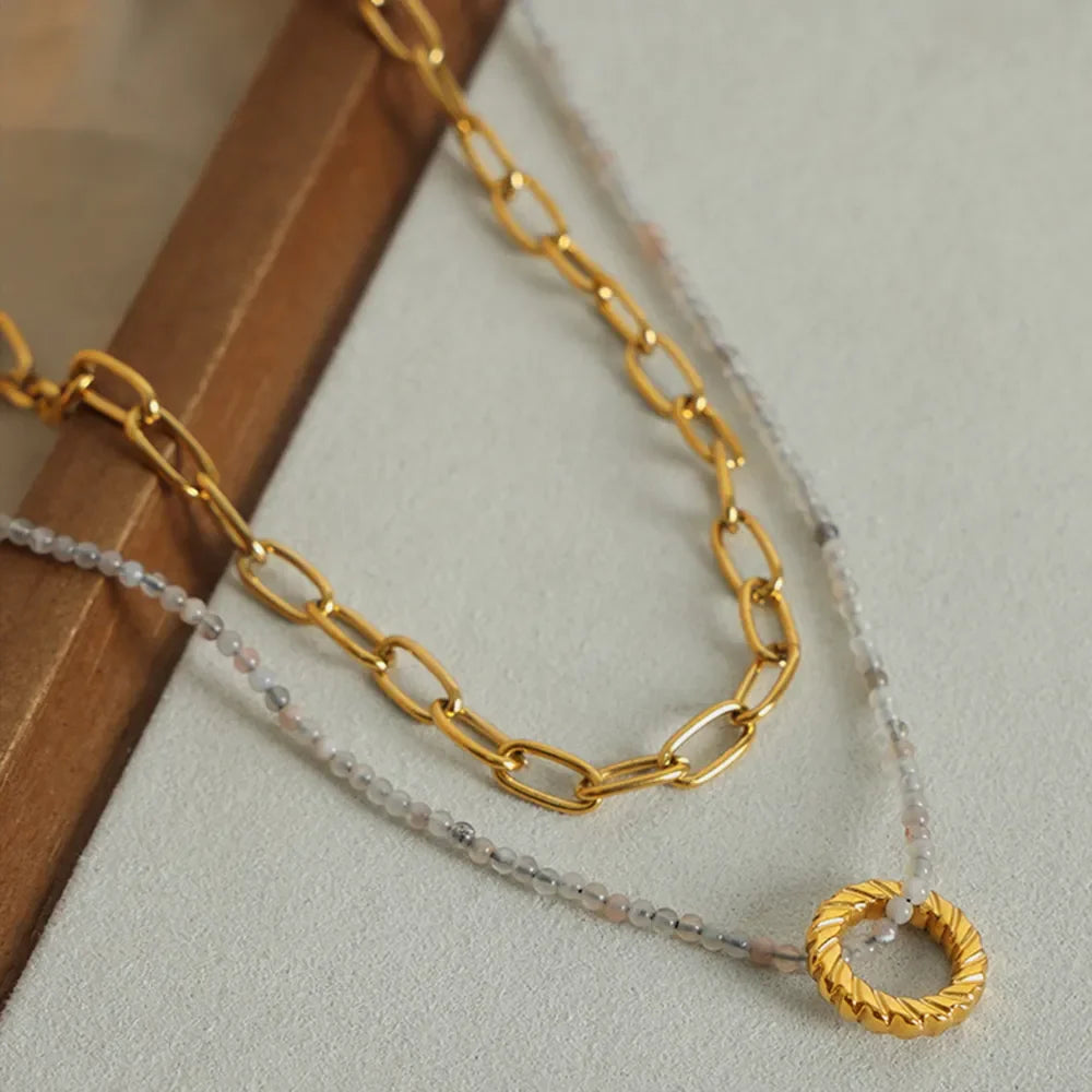 Gold layered necklace with beaded chain and textured ring pendant