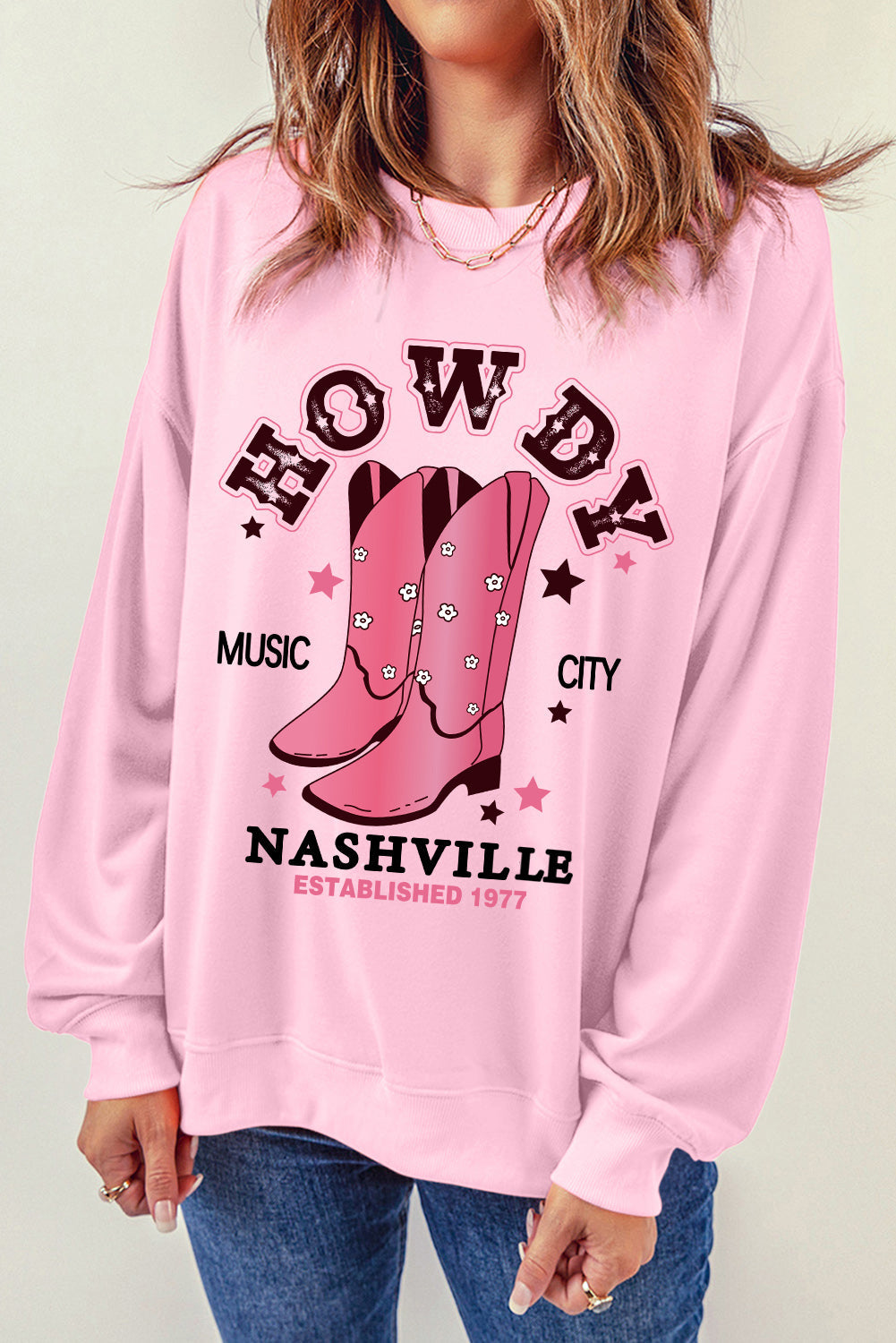 Blush pink crewneck sweatshirt with Nashville graphic and cowboy boots.