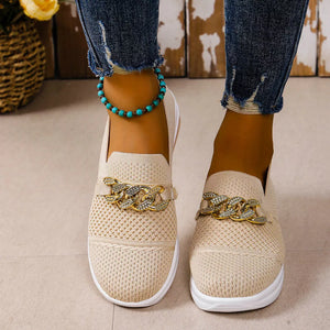 Beige mesh slip-on flats with chunky gold chain detail and white soles.