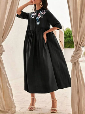 Black midi dress with stand collar, button front, and floral embroidery.