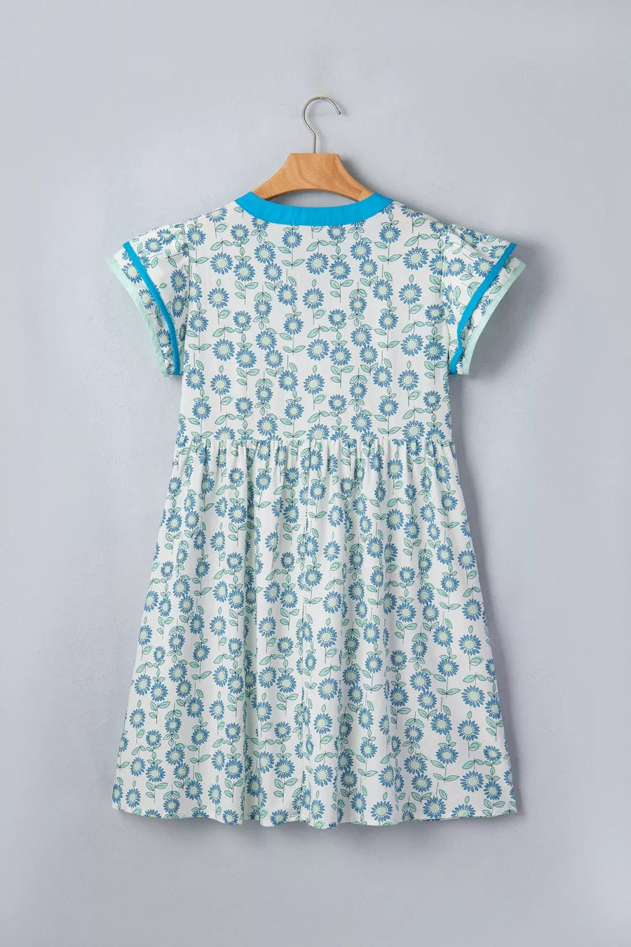Floral dress with notched neckline, cap sleeves, and blue floral print on cotton blend.