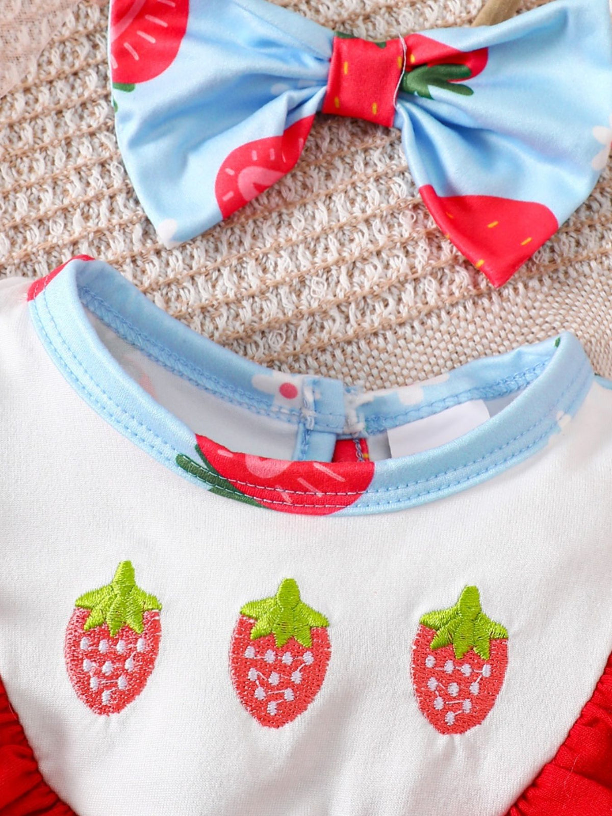Strawberry floral ruffle one-piece set with embroidered strawberries and matching bow.