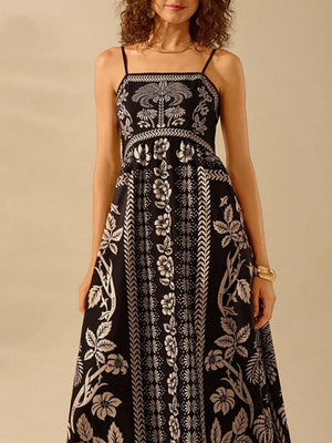 Black floral print spaghetti strap maxi dress with a-line cut and bohemian details.