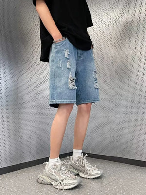 Men's light wash distressed denim shorts with wide leg and raw hem.