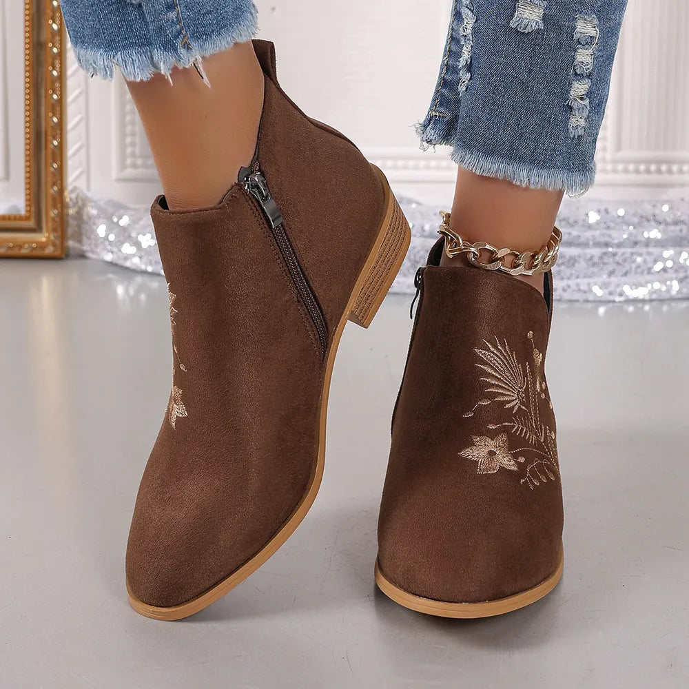 Brown suede ankle boots with side zip and floral embroidery.