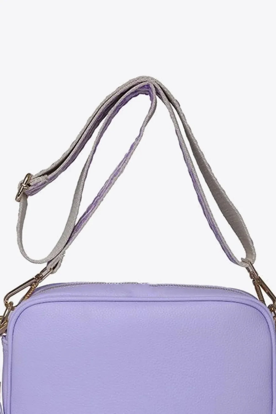 Lavender textured crossbody bag with a woven strap and gold hardware detail.