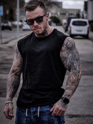 Black sleeveless muscle-fit tank top with a crew neck, worn by a tattooed man.