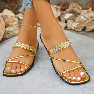 Gold flat sandals with rhinestone embellished straps and thin straps.