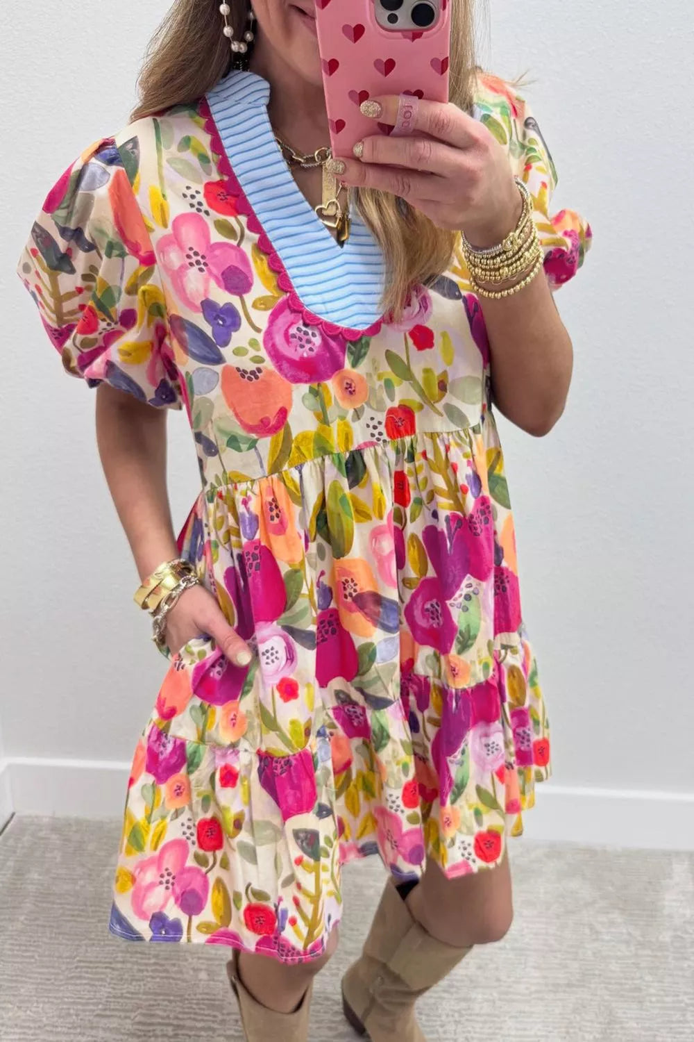 Vibrant floral cotton mini dress with tiered skirt, puff sleeves, and blue striped neckline.