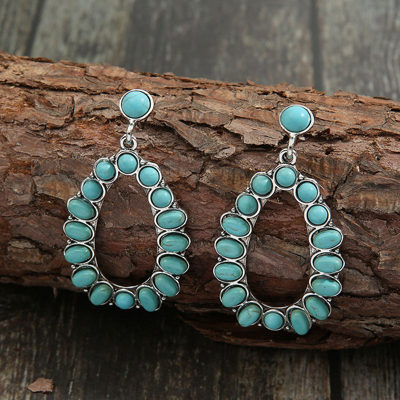 Teal teardrop statement earrings with artificial turquoise stones and alloy setting.