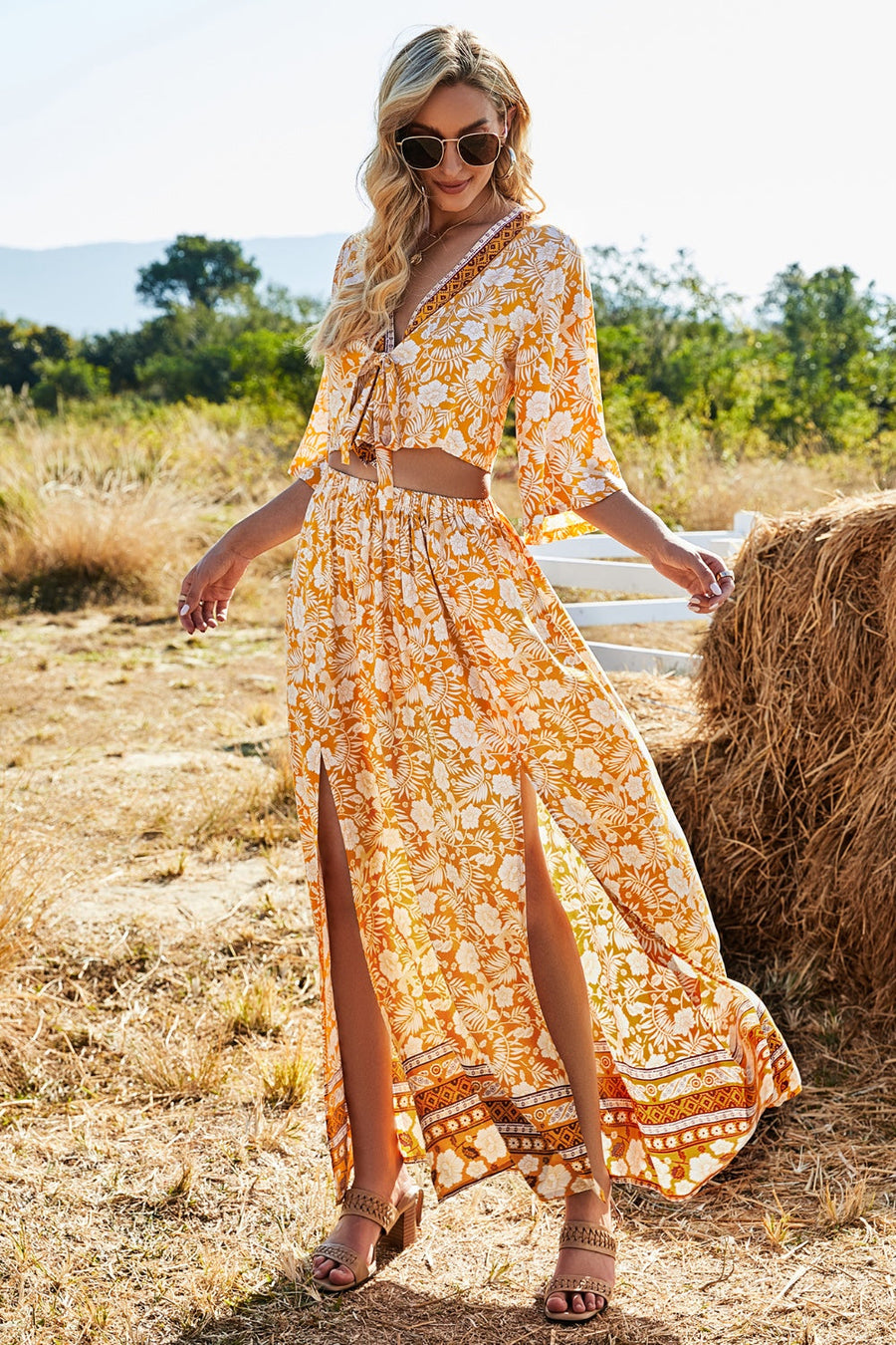 Tangerine floral print crop top with tie front and bell sleeves, paired with a matching maxi skirt with high slits.