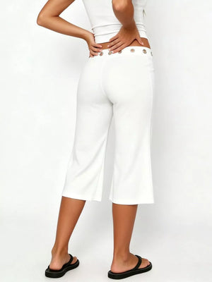 White flared hem capri pants with button detail at the waist