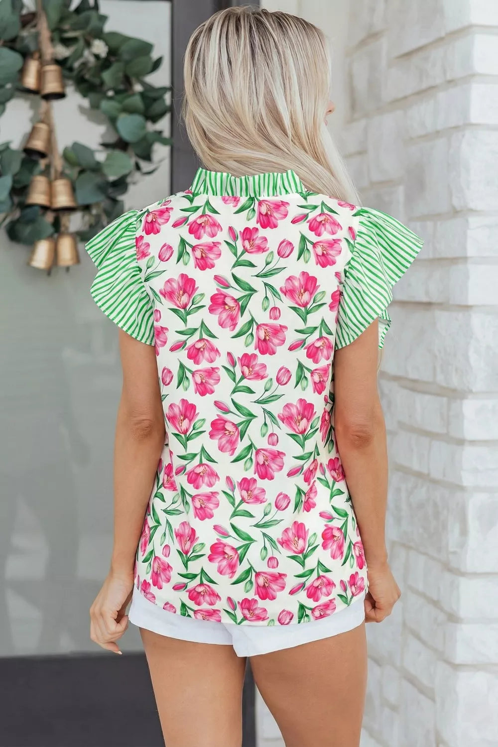 Tulip print ruffled V-neck blouse with green striped sleeves and collar.