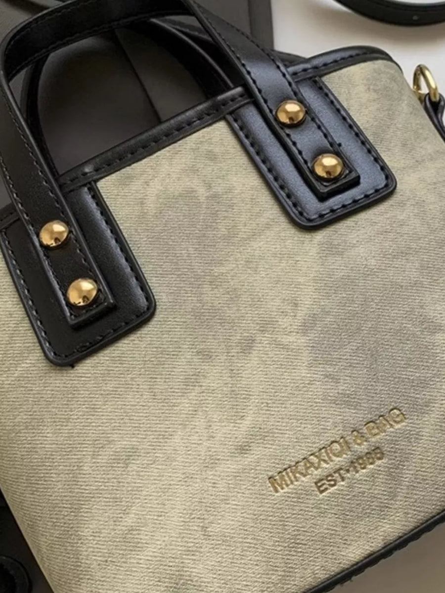 Premium mini chest bag in tan canvas with black leather trim and gold hardware.