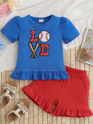 Children's blue baseball LOVE tee with red polka dot letters and red ruffled shorts.